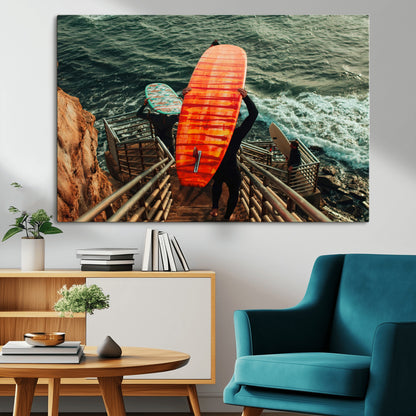 A surfer carrying a bold orange surfboard down a rugged staircase toward the ocean, bathed in golden hour light, capturing the energy of coastal adventure.