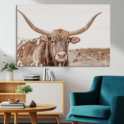 A longhorn cow in soft beige desert tones, standing calmly in open land, perfect for neutral western or rustic farmhouse interiors.