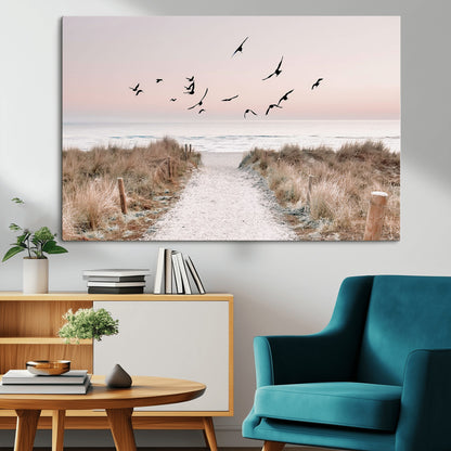 A peaceful coastal pathway leading to the ocean, with birds flying across a soft pastel sky, creating a calm and scenic beach atmosphere.