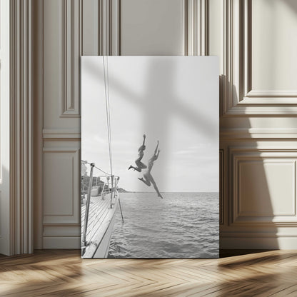 Black and white canvas wall art of two women joyfully jumping off a yacht into the sea, ideal for minimalist coastal or nautical-themed spaces.