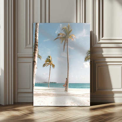 Person leaning on a palm tree at a tropical beach with white sand and turquoise water, perfect for coastal or beach-themed home decor.