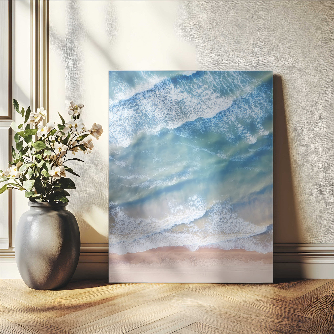 Aerial photo of soft blue waves meeting sandy shore, perfect for modern coastal or beach-themed decor with a light and tranquil aesthetic.