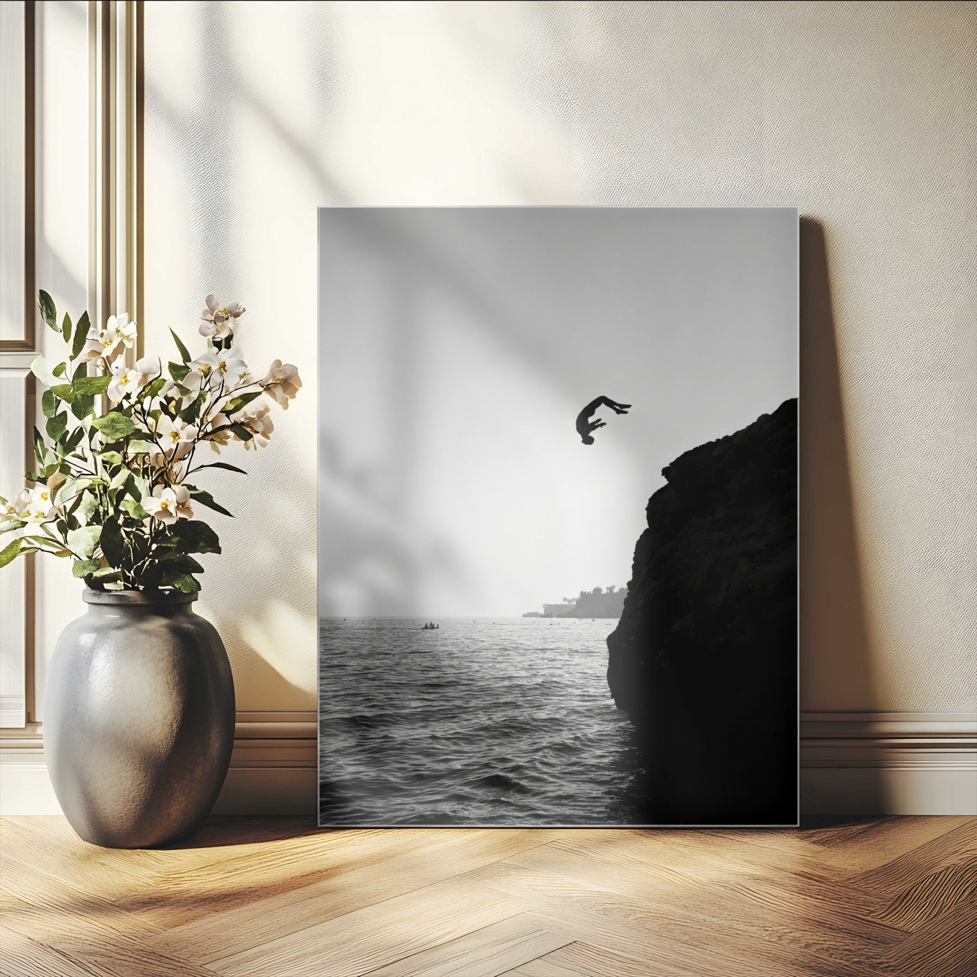 Silhouette of a person mid-air during a cliff jump over the ocean, captured in black and white for minimalist adventure decor.