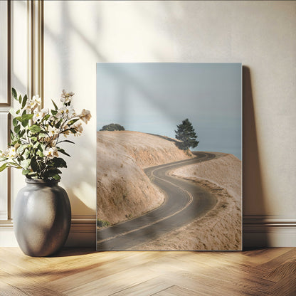 Earth-toned photograph of a winding road through golden hills, ideal for neutral or rustic-themed decor with a calming travel vibe.