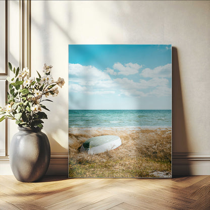 A small boat resting on a grassy shore with ocean waves and a bright blue sky, creating a peaceful coastal atmosphere.