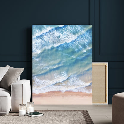 Aerial photo of soft blue waves meeting sandy shore, perfect for modern coastal or beach-themed decor with a light and tranquil aesthetic.