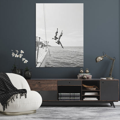 Black and white canvas wall art of two women joyfully jumping off a yacht into the sea, ideal for minimalist coastal or nautical-themed spaces.