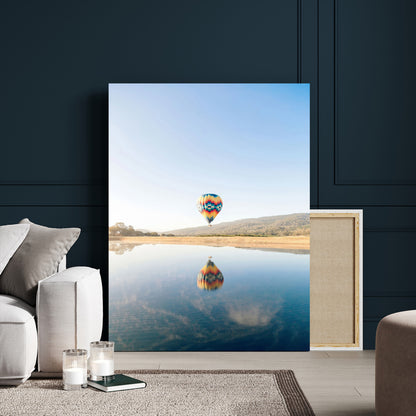 Canvas of a hot air balloon floating above a calm lake with soft reflections and vibrant sky, ideal for modern minimalist or adventure-themed home decor.