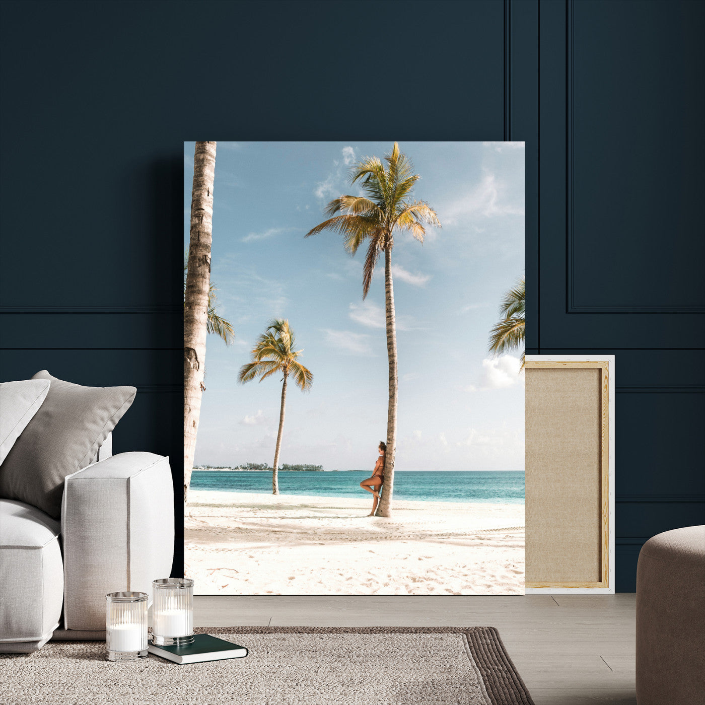 Person leaning on a palm tree at a tropical beach with white sand and turquoise water, perfect for coastal or beach-themed home decor.