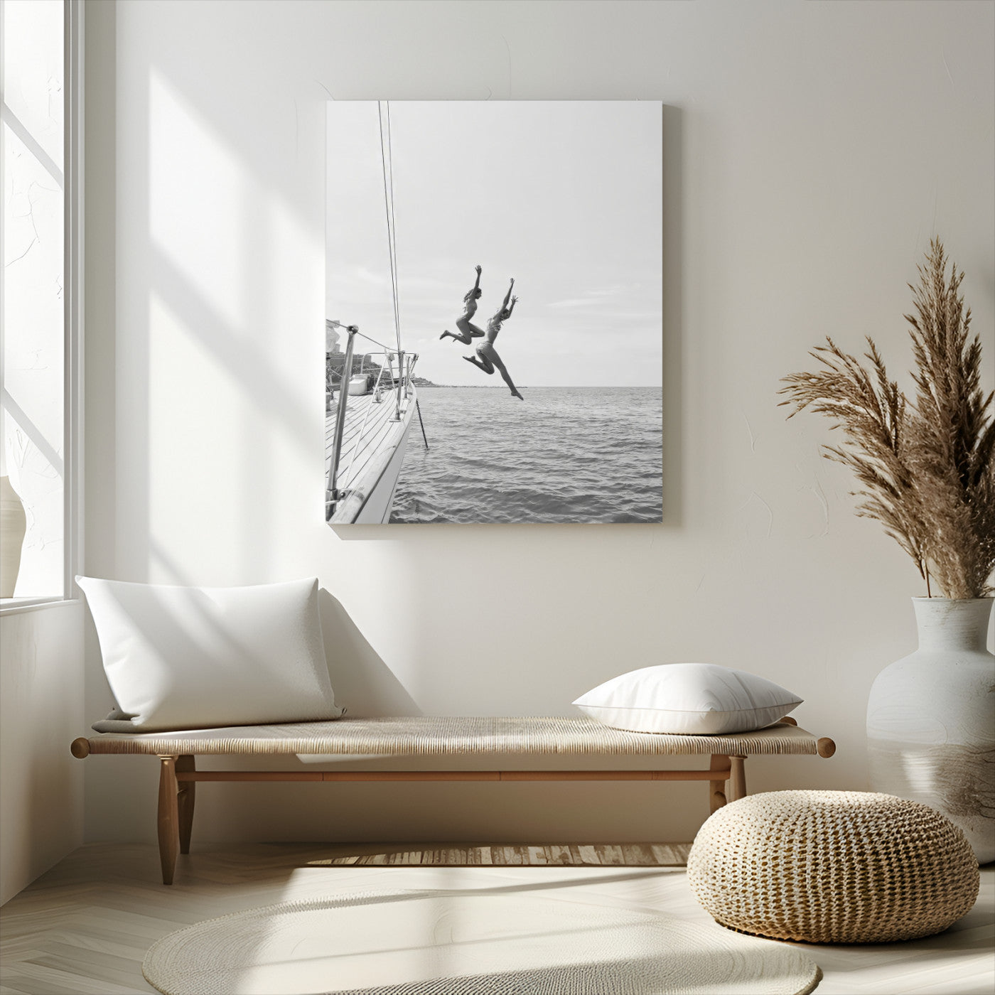 Black and white canvas wall art of two women joyfully jumping off a yacht into the sea, ideal for minimalist coastal or nautical-themed spaces.