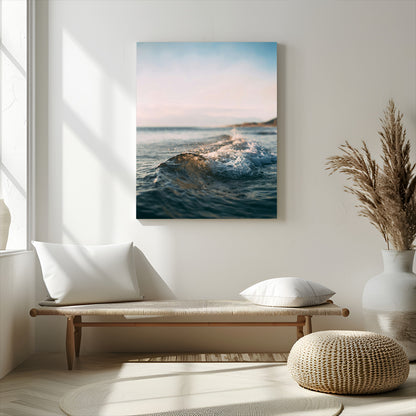 Close-up of ocean waves rolling gently toward the shore at sunset, creating a peaceful and minimalist coastal scene.