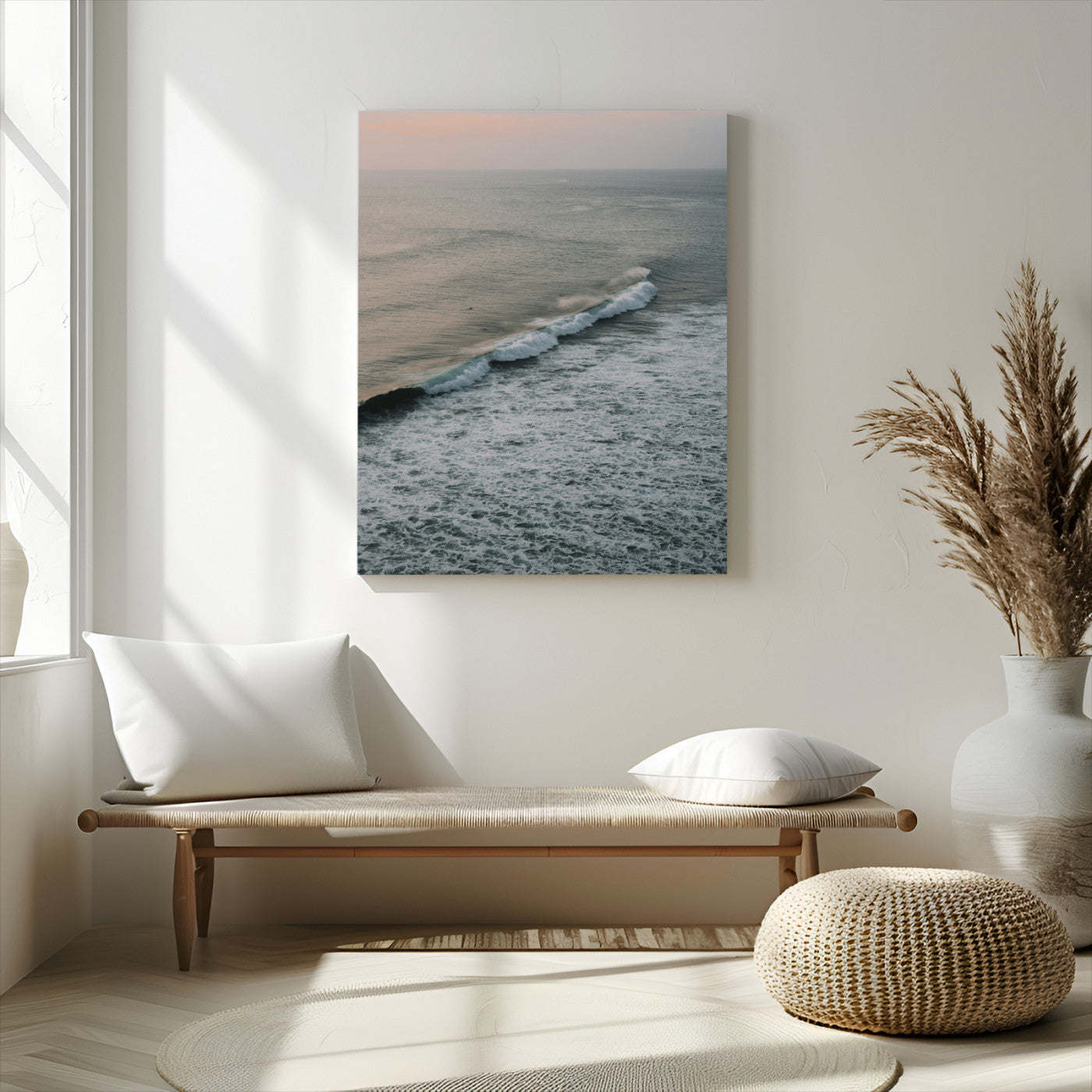 Aerial view of ocean waves rolling towards the shore under a soft sunset sky, creating a peaceful and minimalist coastal scene.
