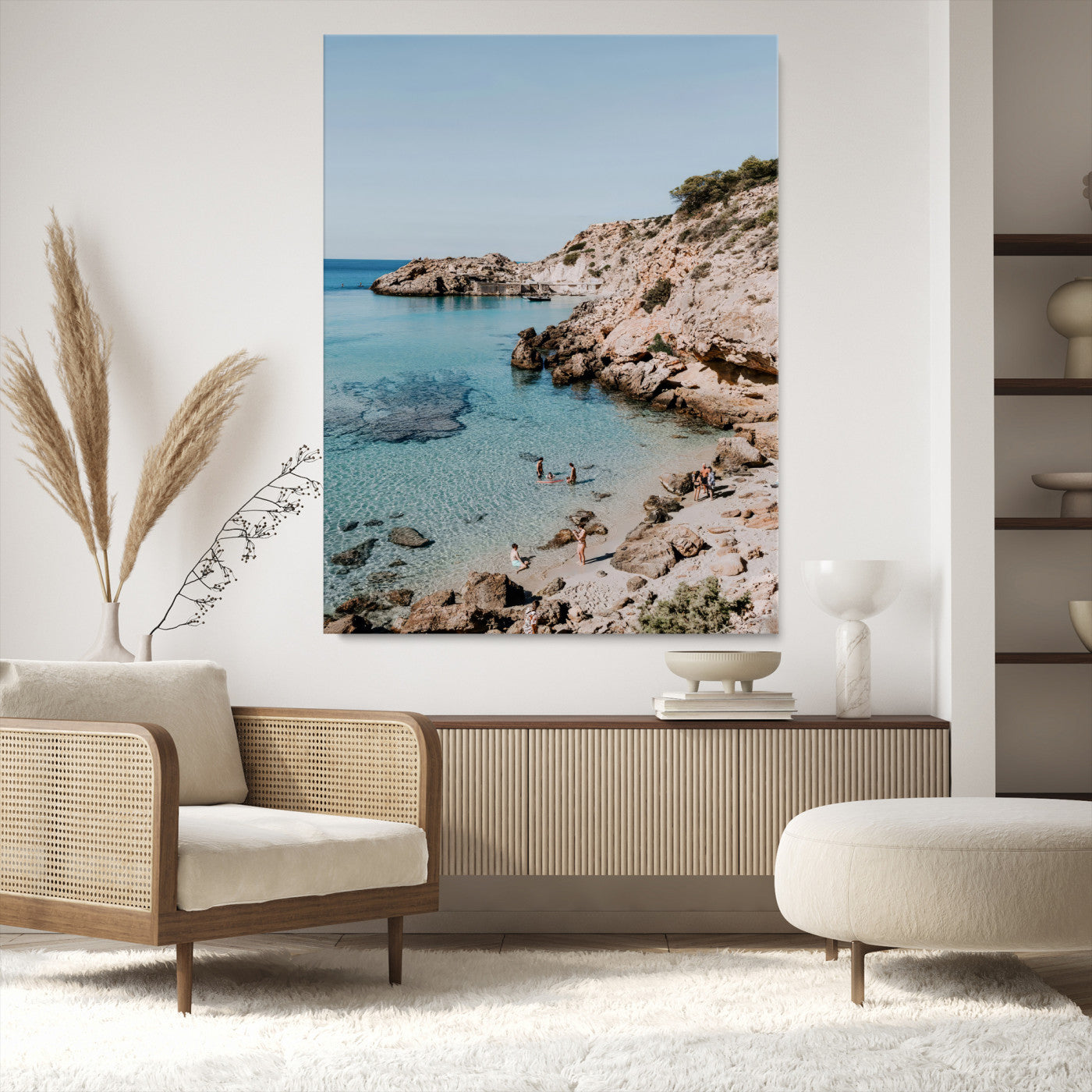 A vibrant coastal photo of a rocky Mediterranean cove with turquoise waters and beachgoers, ideal for boho coastal or summer-inspired interiors.