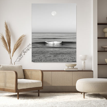 Black and white wall art of a calm ocean wave beneath a full moon, ideal for minimalist or monochrome coastal decor.