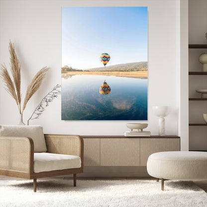 Canvas of a hot air balloon floating above a calm lake with soft reflections and vibrant sky, ideal for modern minimalist or adventure-themed home decor.