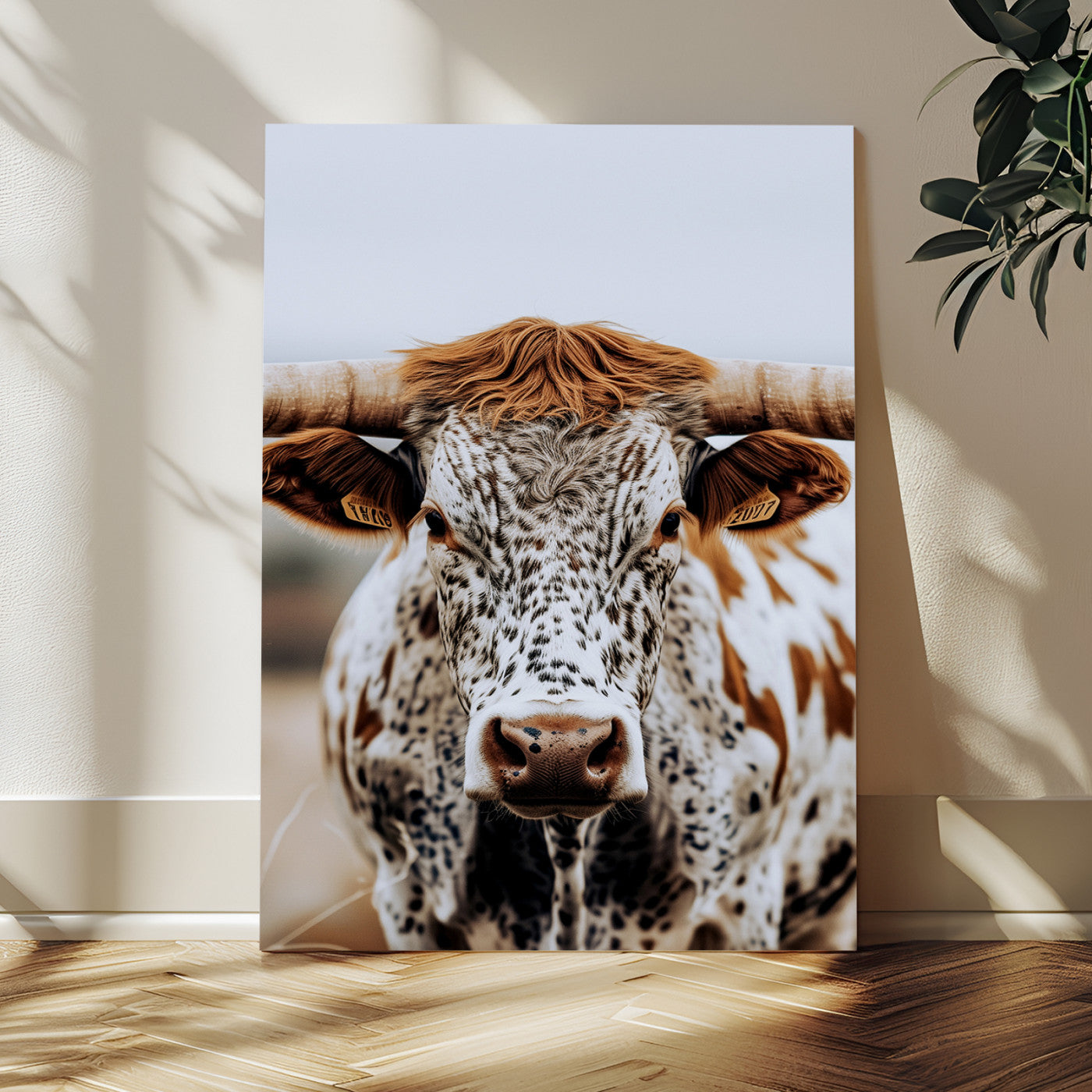 Close-up of a speckled Texas longhorn with wide horns and a bold gaze, perfect for rustic or country-style decor in warm tones.