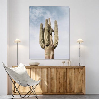 Vertical photo of a tall saguaro cactus against a soft sky, ideal for earthy or Southwestern home decor with warm neutral tones.