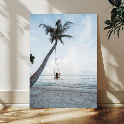 Wall art of a girl on a swing hanging from a palm tree over calm ocean waters, perfect for tropical or minimalist coastal decor.