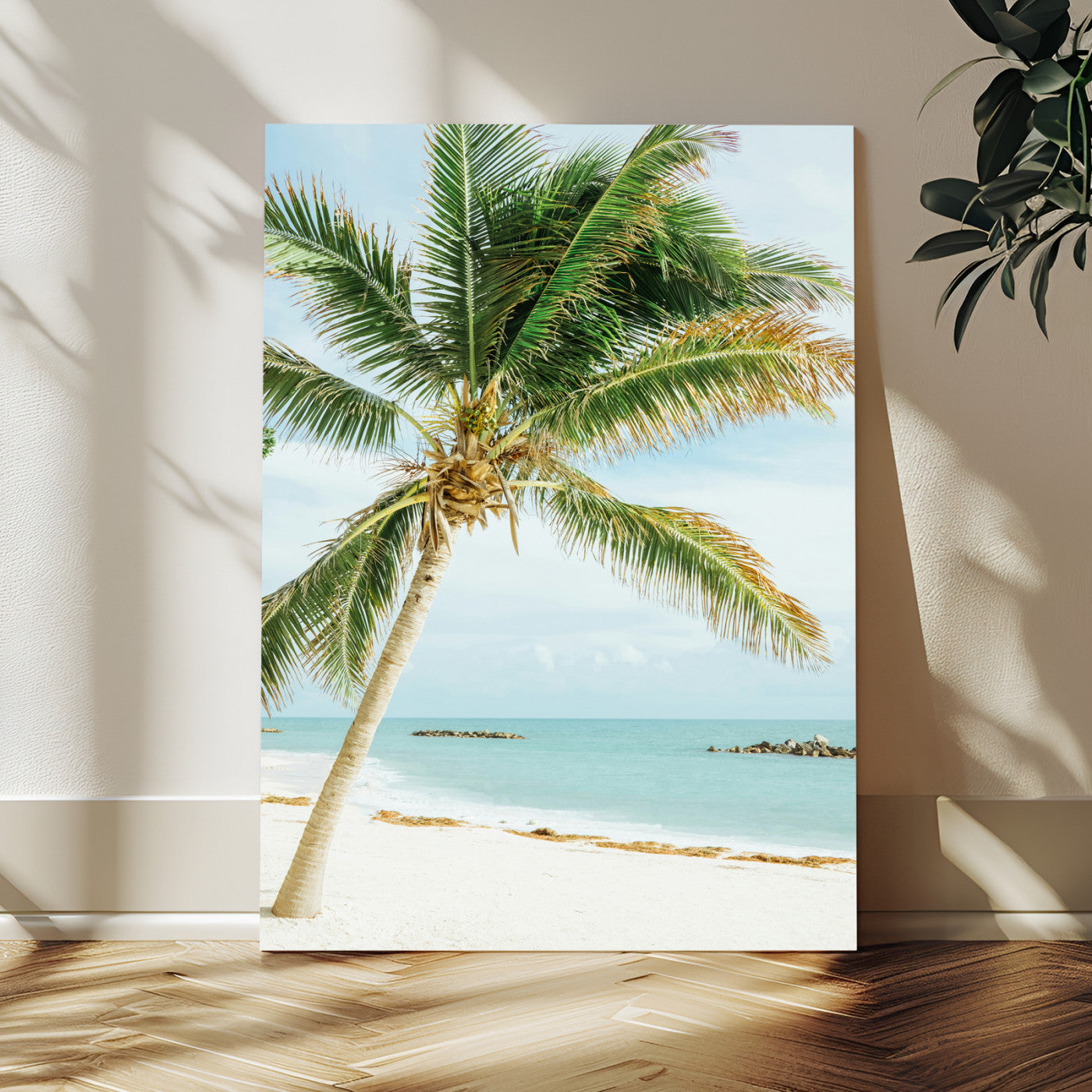 A tall palm tree leaning over a white sandy beach with turquoise ocean waves, creating a peaceful and tropical coastal scene.