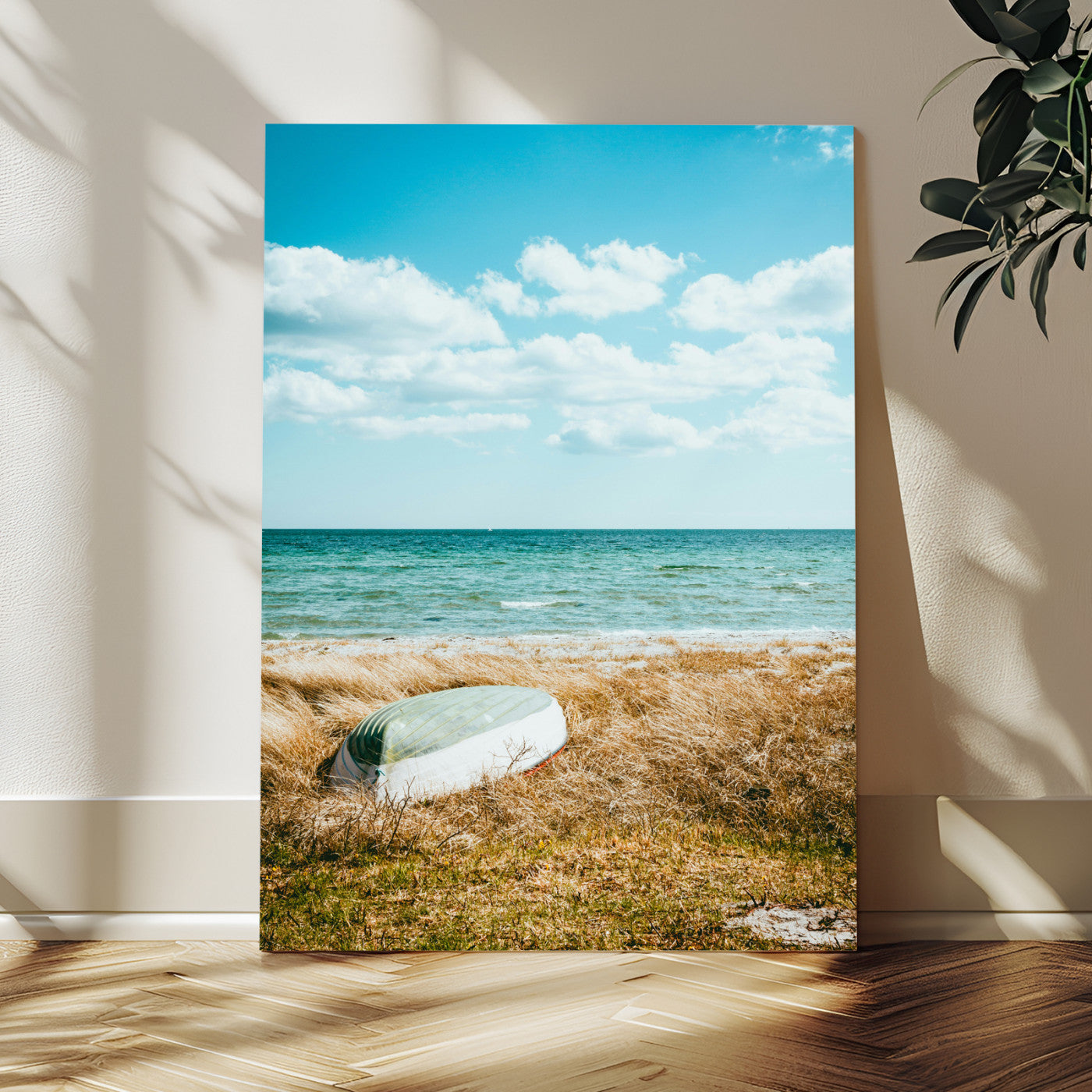 A small boat resting on a grassy shore with ocean waves and a bright blue sky, creating a peaceful coastal atmosphere.