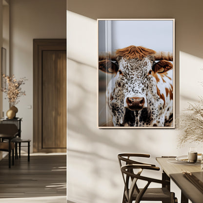 Close-up of a speckled Texas longhorn with wide horns and a bold gaze, perfect for rustic or country-style decor in warm tones.