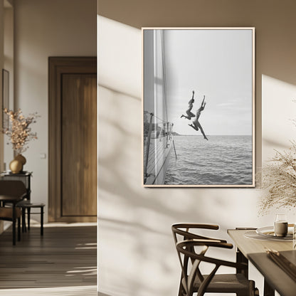 Black and white canvas wall art of two women joyfully jumping off a yacht into the sea, ideal for minimalist coastal or nautical-themed spaces.