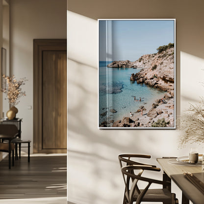 A vibrant coastal photo of a rocky Mediterranean cove with turquoise waters and beachgoers, ideal for boho coastal or summer-inspired interiors.