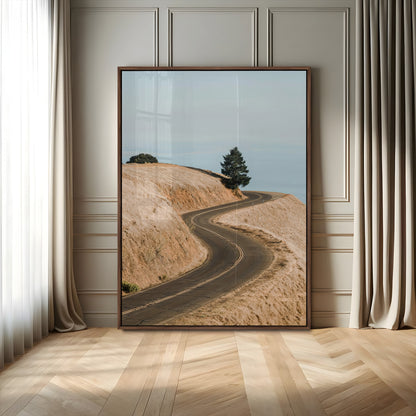 Earth-toned photograph of a winding road through golden hills, ideal for neutral or rustic-themed decor with a calming travel vibe.