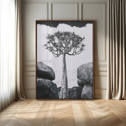 Tall desert tree in black and white, standing between large rocks, perfect for bold and minimalist nature-themed interior spaces.
