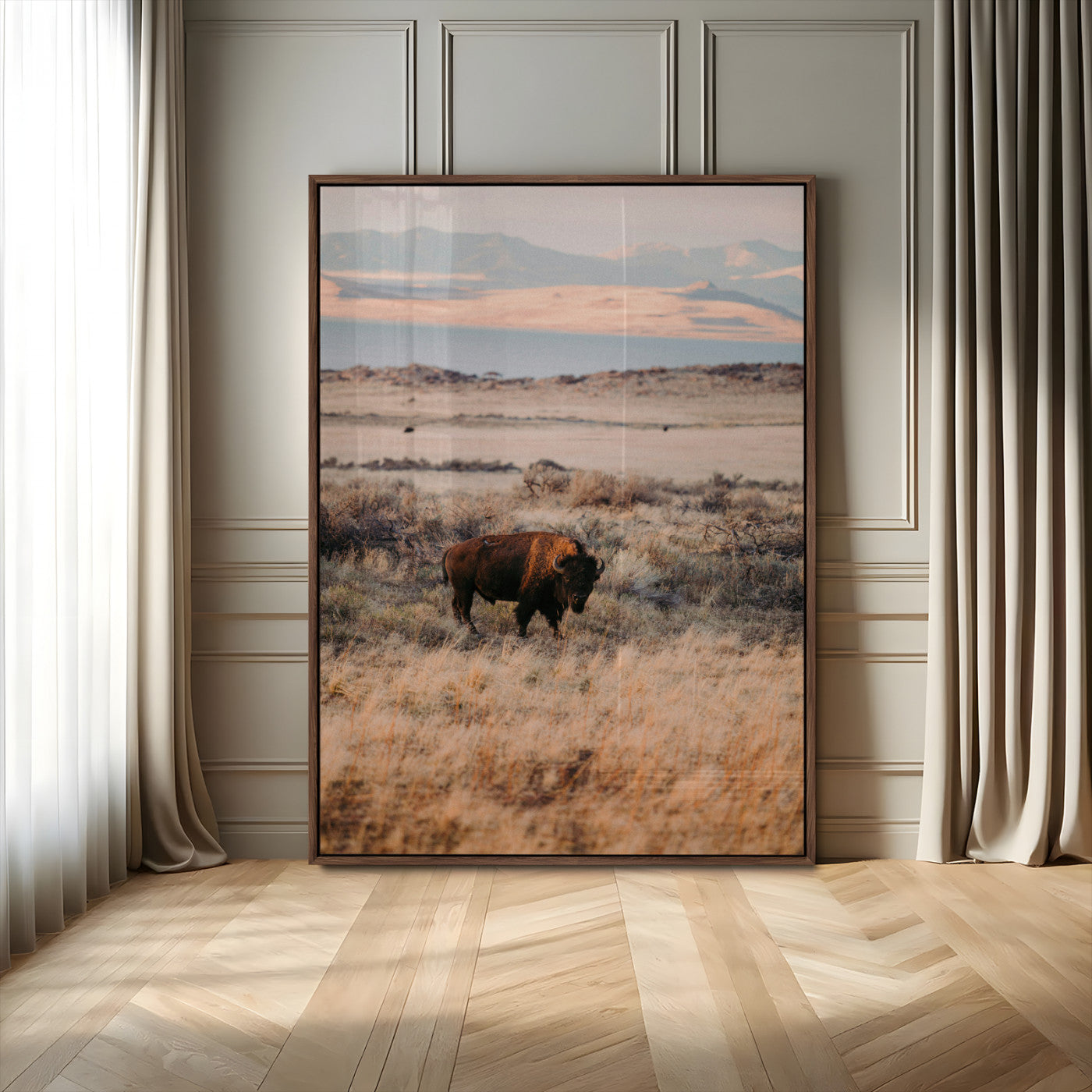 A solitary bison standing in golden prairie grass with distant mountains and soft sunset light, ideal for rustic, lodge, and western decor.