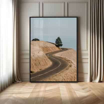 Earth-toned photograph of a winding road through golden hills, ideal for neutral or rustic-themed decor with a calming travel vibe.