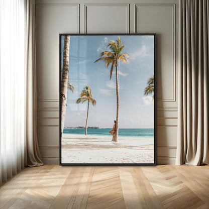 Person leaning on a palm tree at a tropical beach with white sand and turquoise water, perfect for coastal or beach-themed home decor.