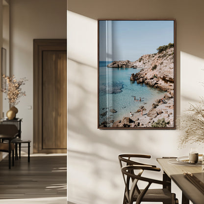 A vibrant coastal photo of a rocky Mediterranean cove with turquoise waters and beachgoers, ideal for boho coastal or summer-inspired interiors.