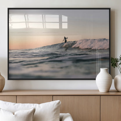 Framed canvas of a female surfer balancing on a wave at sunset, perfect for serene surf or ocean-inspired coastal decor.