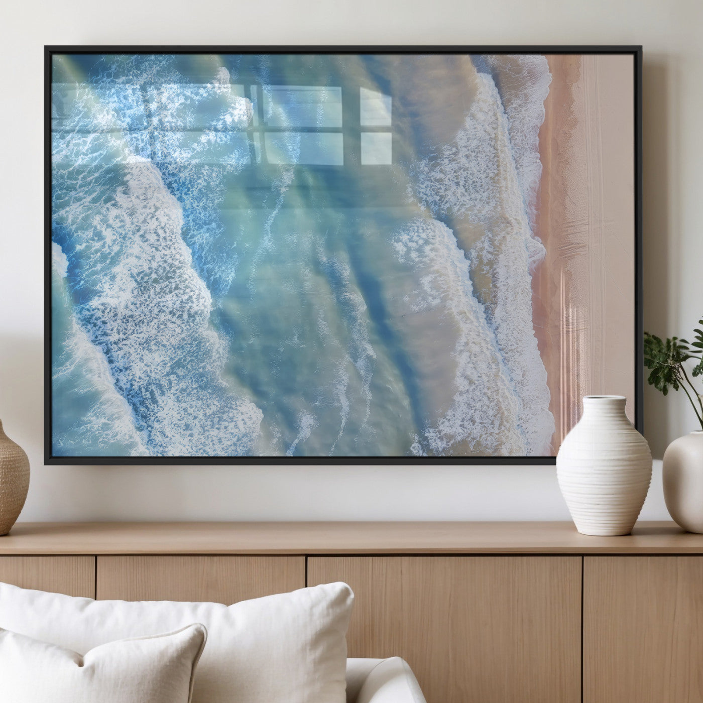 Aerial photo of soft blue waves meeting sandy shore, perfect for modern coastal or beach-themed decor with a light and tranquil aesthetic.