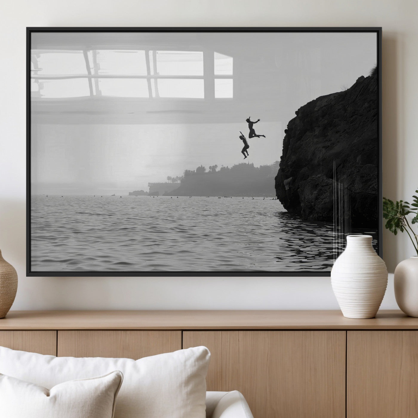 Black and white canvas of two figures cliff jumping into the sea, captured with moody tones, ideal for modern coastal or adventure-themed home decor.   2/2