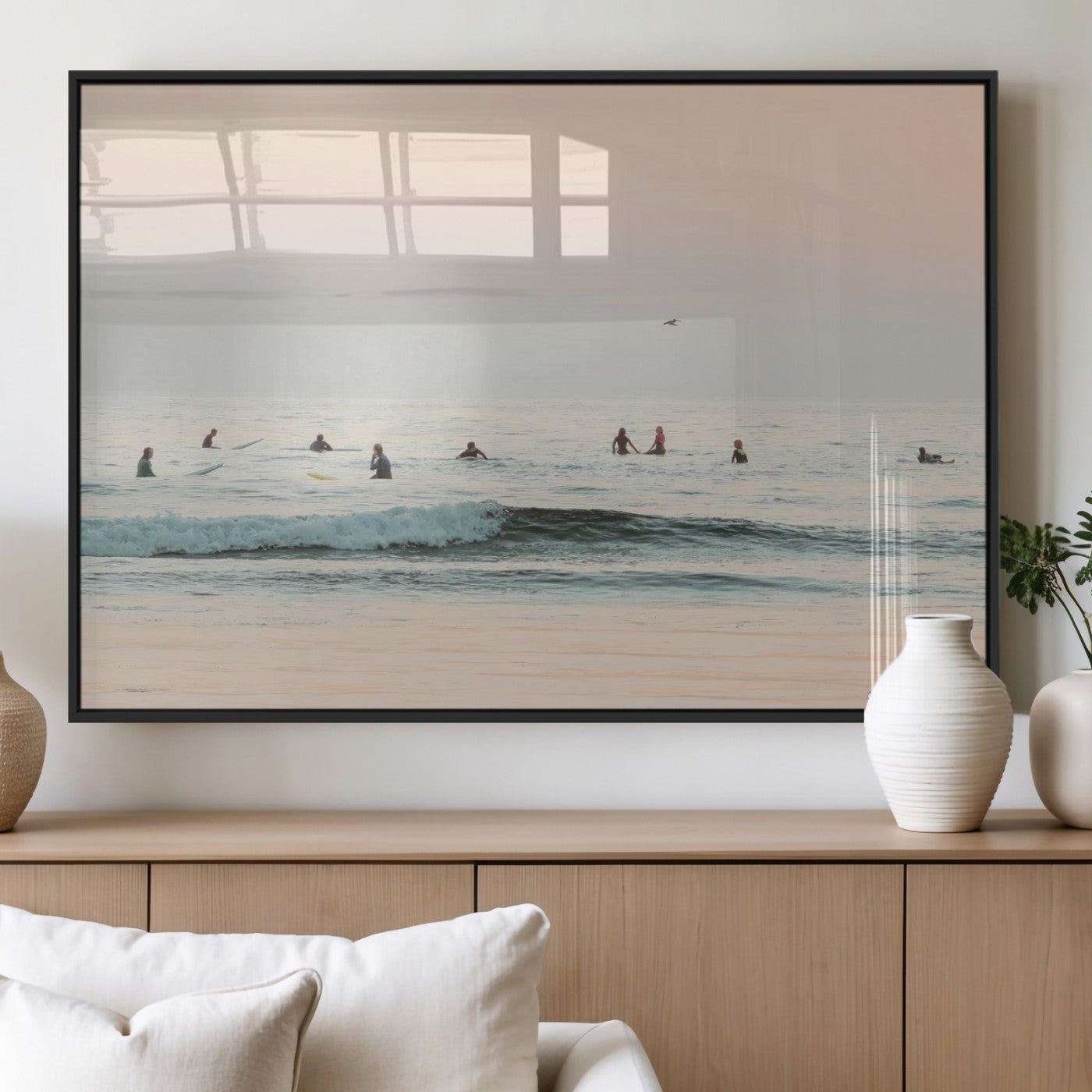 Dreamy photo of surfers waiting on soft pastel waves under a pink sunset sky, ideal for soft coastal minimalist or serene ocean-themed home decor.