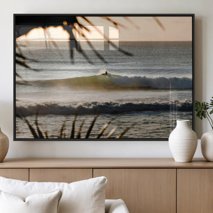 Photo of a surfer riding a golden hour wave at sunset, with tropical tones and dreamy light, perfect for tropical boho or coastal home decor.