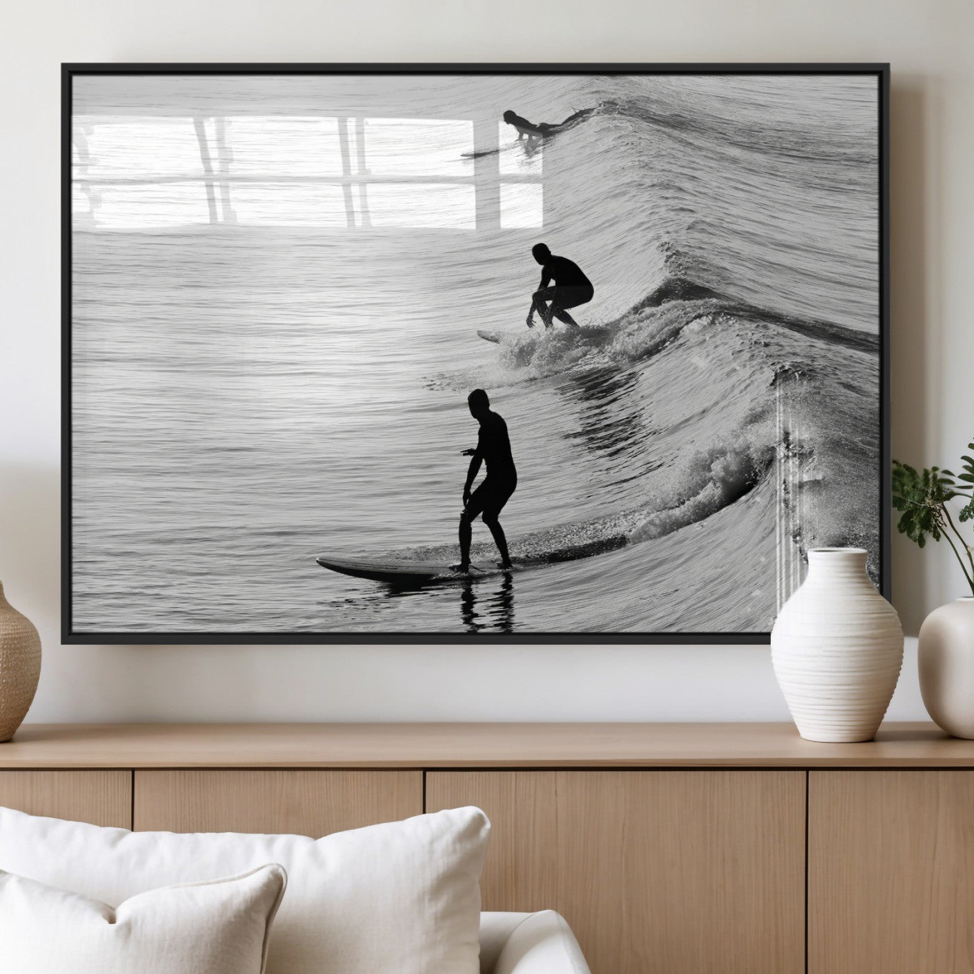 Black and white photo of surfers riding waves in a moody, high-contrast scene, ideal for modern coastal or surf-inspired home decor.