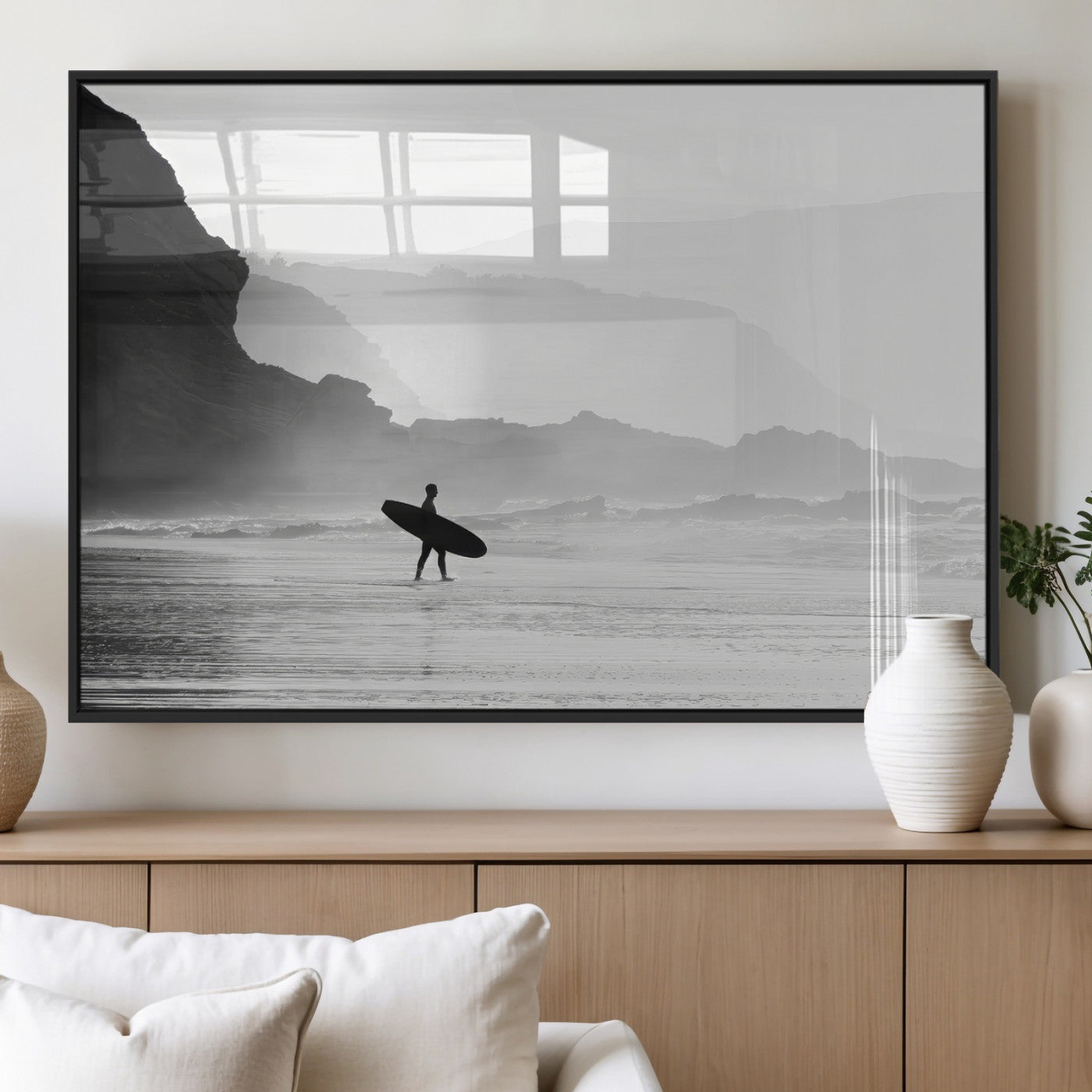 A lone surfer walking along a misty beach with cliffs in the background, carrying their board, capturing a serene and minimal ocean moment.