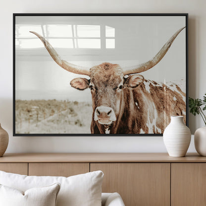 A Texas longhorn bull with wide horns, standing in a dry field under soft light, ideal for rustic farmhouse or western-themed interiors.