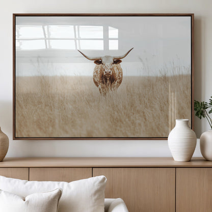 Texas Longhorn bull standing alone in dry grass with neutral tones, ideal for rustic western or cowboy-themed wall decor.