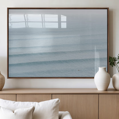 Framed canvas of repeating ocean waves with a distant solo surfer, ideal for minimalist ocean or calm coastal wall decor.