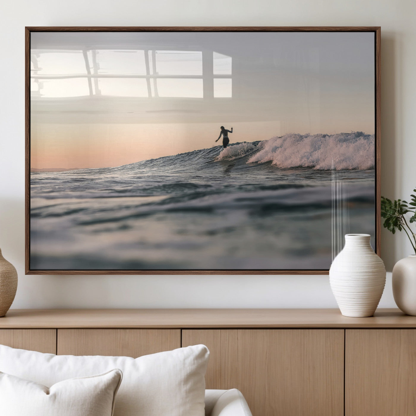 Framed canvas of a female surfer balancing on a wave at sunset, perfect for serene surf or ocean-inspired coastal decor.
