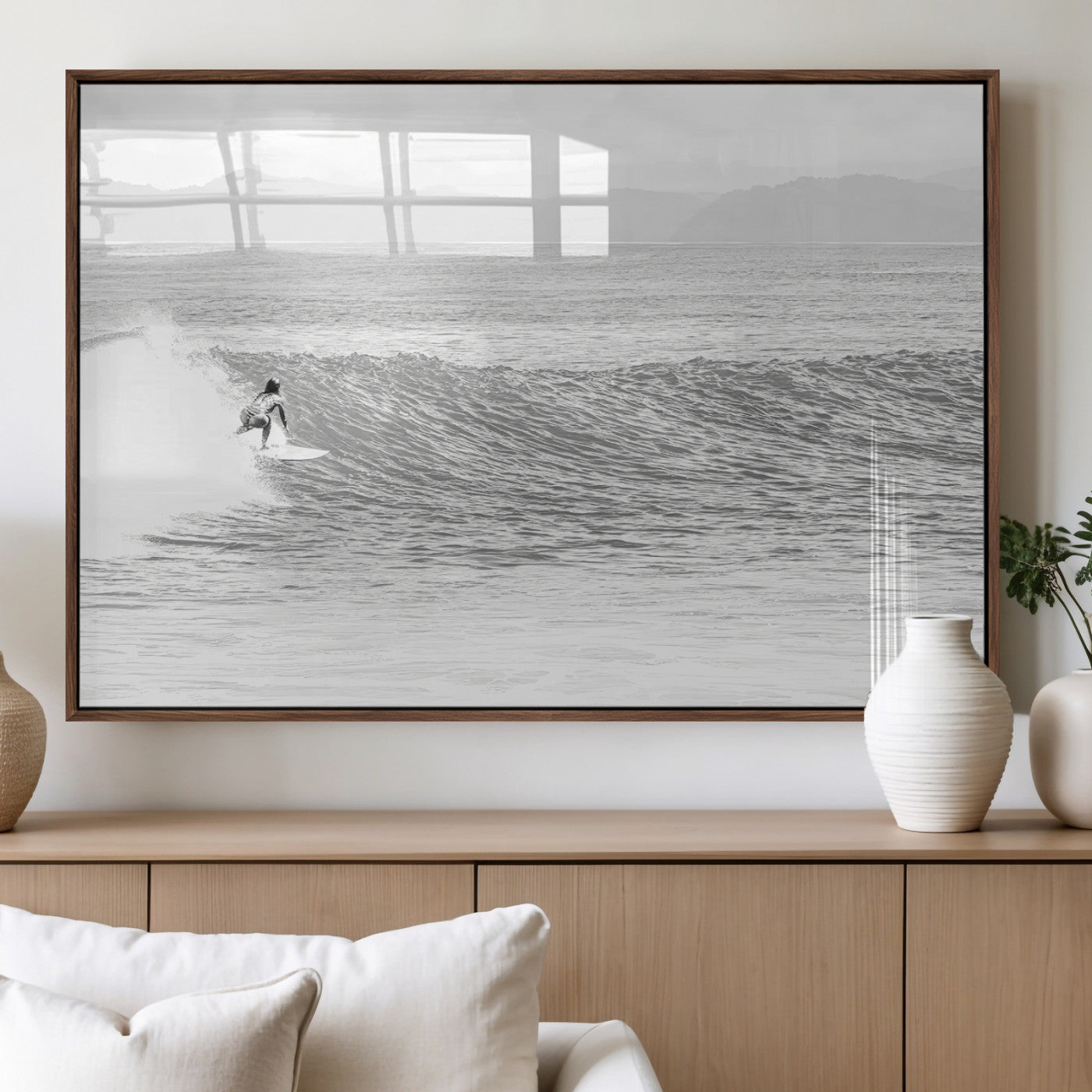 Monochrome photo of a surfer riding a wave with distant mountains, ideal for coastal motion or black and white surf-themed wall decor.