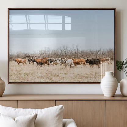 Framed wall art of Texas longhorn cattle walking through a dry, neutral-toned prairie, perfect for rustic farmhouse or western-themed home decor.