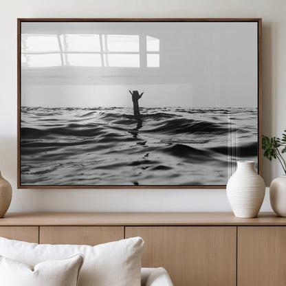 Black and white ocean with a hand making a surfer sign among dark waves, creating a dramatic and minimalist seascape with bold contrast.