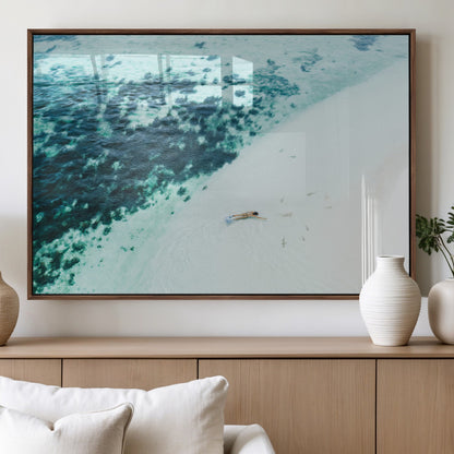 Canvas featuring an aerial view of a swimmer in shallow turquoise waters with coral patterns, ideal for tropical coastal home decor.