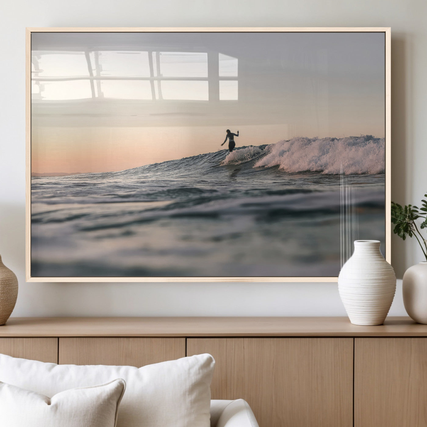 Framed canvas of a female surfer balancing on a wave at sunset, perfect for serene surf or ocean-inspired coastal decor.