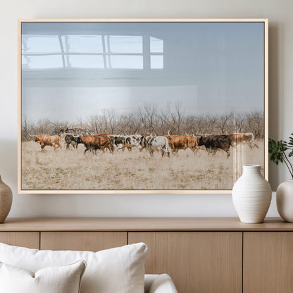 Framed wall art of Texas longhorn cattle walking through a dry, neutral-toned prairie, perfect for rustic farmhouse or western-themed home decor.